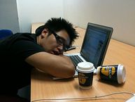 Office worker falling asleep over his keyboard