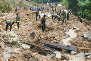 Rescuers search for victims of a landslide.