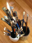 A wide variety of paint brush types displayed in cups