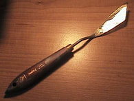 A wooden-handled artist's painting knife.