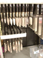 A wide variety of painting knives hanging at an art supply store.